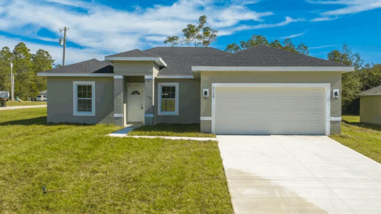 Fachada de casa unifamiliar de una planta con cochera y césped.
